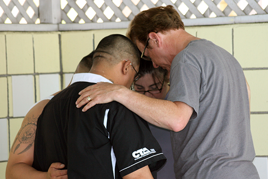 Pastor Ron prays with a family before they are baptized at Motel Church